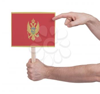 Hand holding small card, isolated on white - Flag of Montenegro