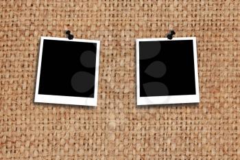 two empty photos stuck by pin to the texture of grey sacking
