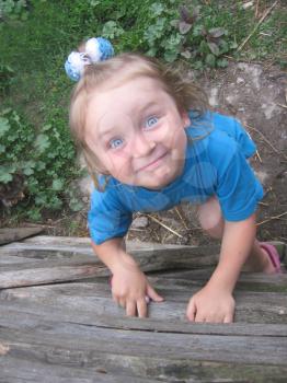little girl with blue eyes staring up and smiling