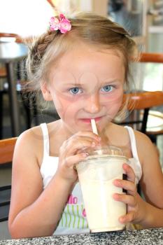 little beautiful girl drinking tasty cocktail in fastfood