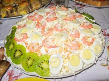 Tasty salad decorated kiwi, boiled eggs and shrimps