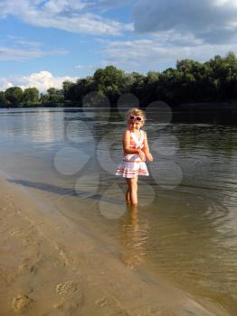 little girl standing in the beautiful river
