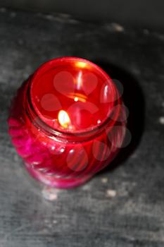 Candle burning in the red candlestick in church