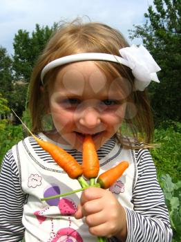 image of girl biting the ripe orange carrot