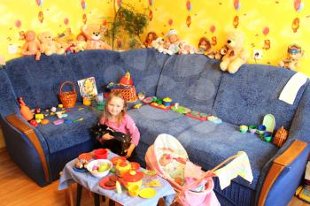 little girl playing with toys and cat in her room