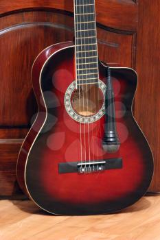 guitar and microphoneon the wooden dark background