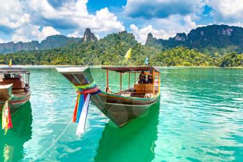Wooden thai traditional long tail boat on Cheow Lan lake, Ratchaprapha Dam, Khao Sok National Park in Thailand in a summer day