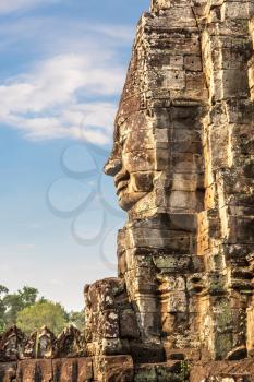Stone face of Bayon temple is Khmer ancient temple in complex Angkor Wat in Siem Reap, Cambodia in a summer day