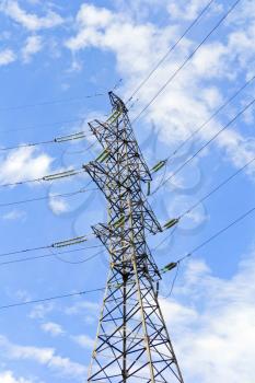 High Voltage Power Lines And Large Pylon Above Blue Sky