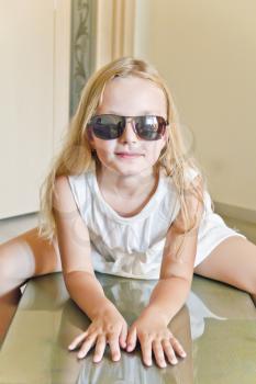 Photo of cute girl playing with sunglasses