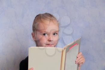 Portrait of girl with blond hair reading a book