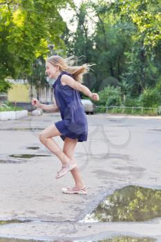 Cute jumping European blond girl in summer
