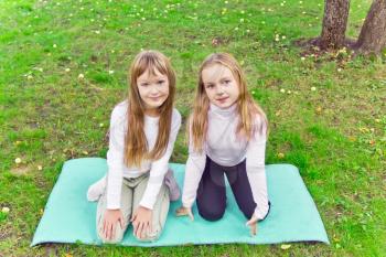 Photo of two girls sitting on grass in summer