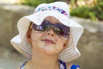 Cute girl in sunglass and white hat