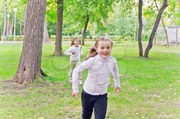 Photo of two running girls in summer