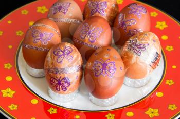Easter eggs with butterflies on red plate