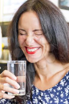 Photo of beautiful smiling brunette drinking water