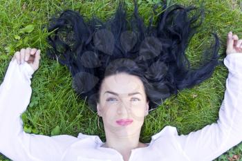 European brunette woman in white on green grass