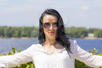 Standing young Caucasian woman on river background