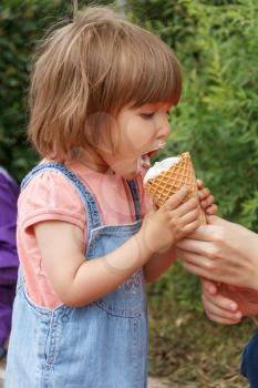 Vertical photo of cute girl are eating icecream in summer time
