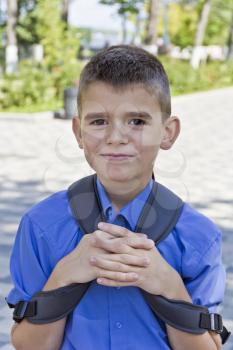 Cute smiling brunette boy with school backpack