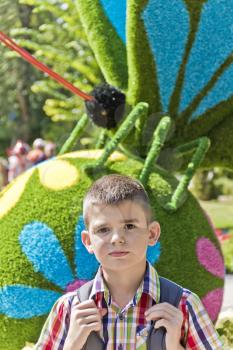 Cute brunette boy eleven years old in flowers background