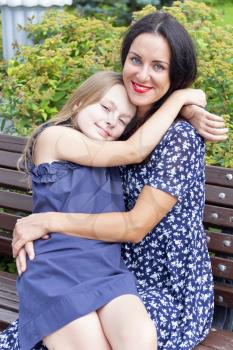 Portrait of loving brunette mother and blond daughter 