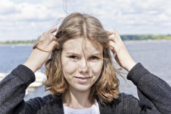 Portrait of cute blond girl are straightening hair