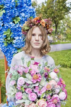 Portrait of cute blond girl fourteen years old in flowers wreath