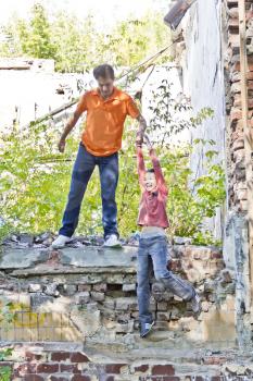 Father and teenager son are playing in ruins