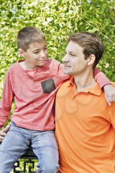 Father and son are talking and looking to each others in summer