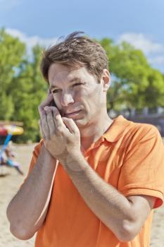 Portrait of man in orange talking by mobile