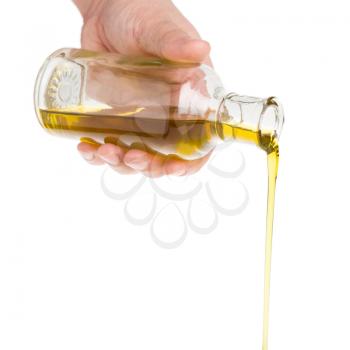 Male hand holding a bottle. Oil pouring from a bottle.