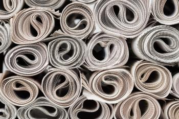 Stack of newspapers rolls, texture background.