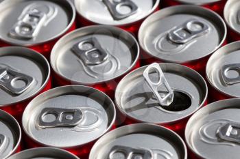 Red soda cans, top view, with one opened