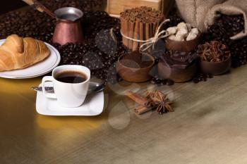 Still-life with coffee, cup with saucer, coffee mill, sac with beans and spices. Coffee time concept