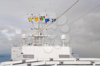 flags of european countries on navigation antenna of cruise liner