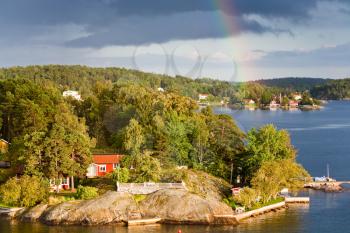 rainbow under small village on Baltic seashore