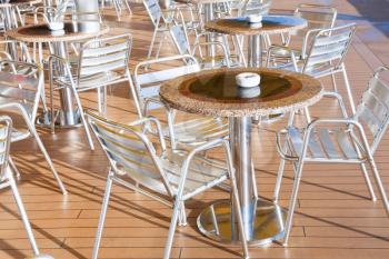 tables with ashtrays in outdoor bar on stern of cruise liner