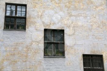 three old windows in stone house wall