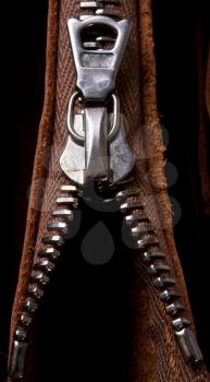 brass zipper lock in unzip leather bag. close-up