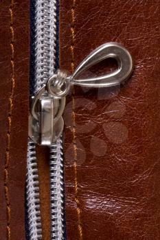 steel zipper lock in unzip leather bag. close-up