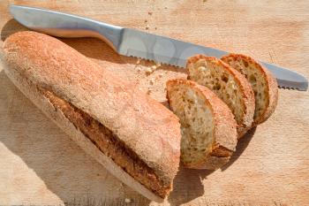 bread knife and bread on wooden board