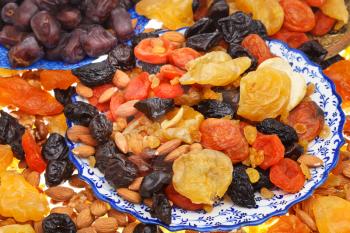 sweet dried fruits on asian plates close up