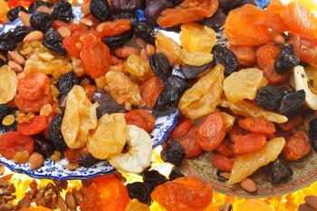 top view of oriental dessert - dried sweet fruits and nuts on plates