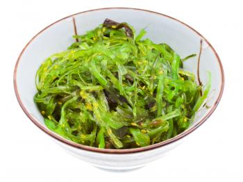 chuka salad - seaweed salad sprinkled with Sesame Seeds in ceramic bowl isolated on white background