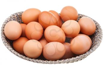 many fresh chicken eggs in wicker basket isolated on white background