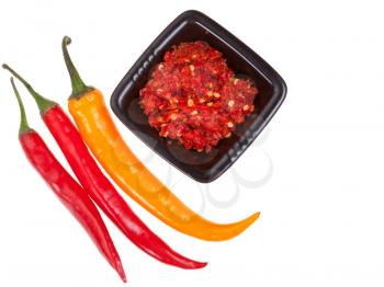 three peppers and spicy sauce isolated on white background