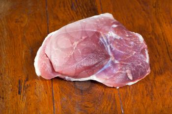 piece of raw pork meat on wooden table