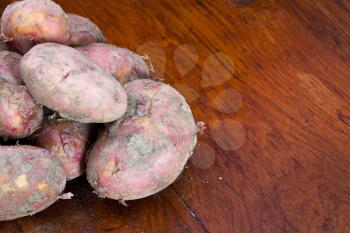 new pink potatoes on wooden table